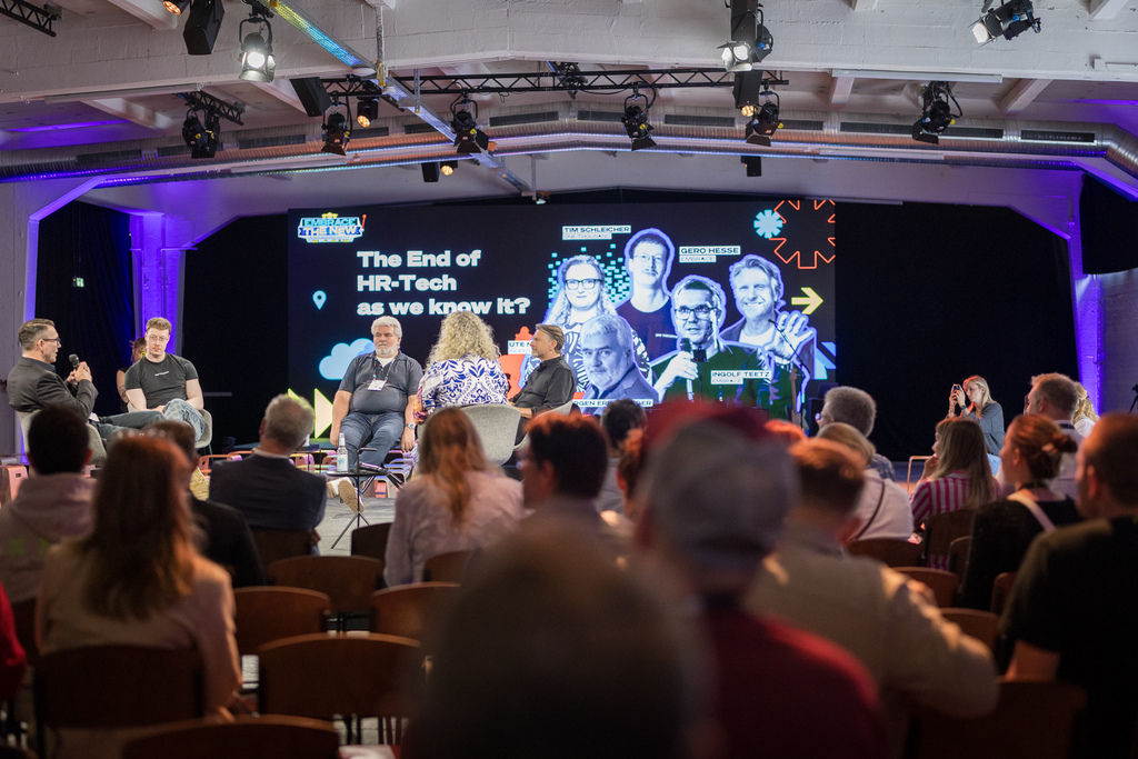 Kleine Bühne mit Publikum an Tischen beim EMBRACE Festival 2026