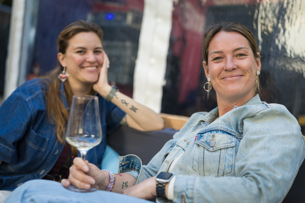 Zwei Gäste lachen bei einem Glas Wein beim EMBRACE Festival 2026